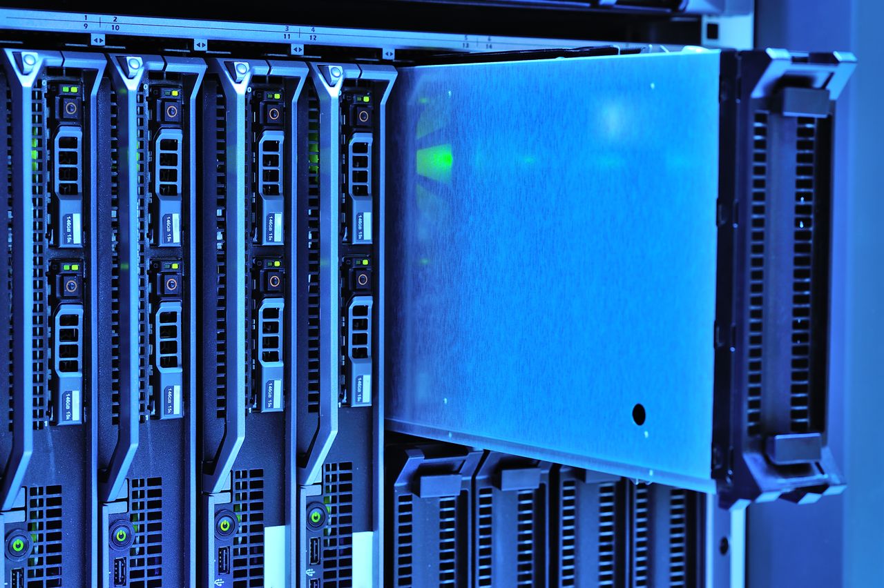our-story Detailed view of server racks with glowing lights in a data center environment.